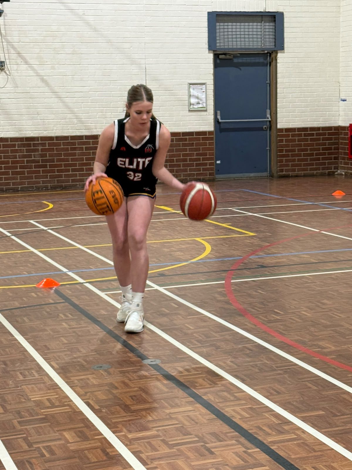 A player works on a two-ball dribbling drill at training